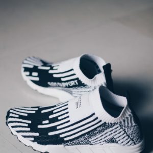 shallow focus photo of pair of white-and-black running shoes