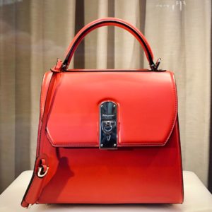 red leather handbag on white table