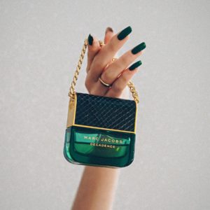 person holding green and black labeled bottle